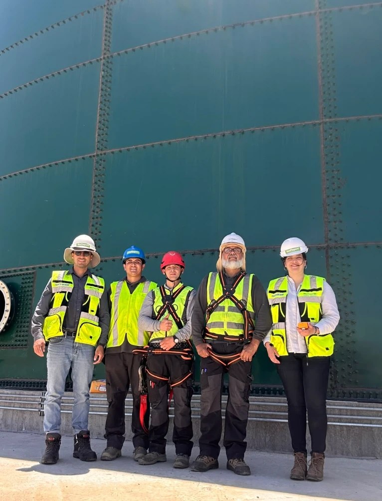 Equipo de Neoplagas con casco, chaleco y arnés frente a un estanque de agua antes de la limpieza