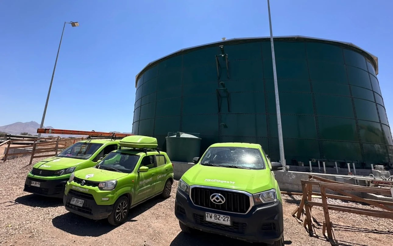 Vehículos de Neoplagas junto a un estanque de agua potable industrial
